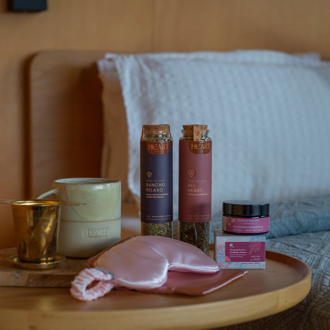 Table with skincare products and a candle in a bedroom setting