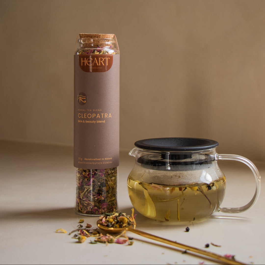 Kinto One Touch glass teapot brewing Cleopatra herbal tea beside its jar