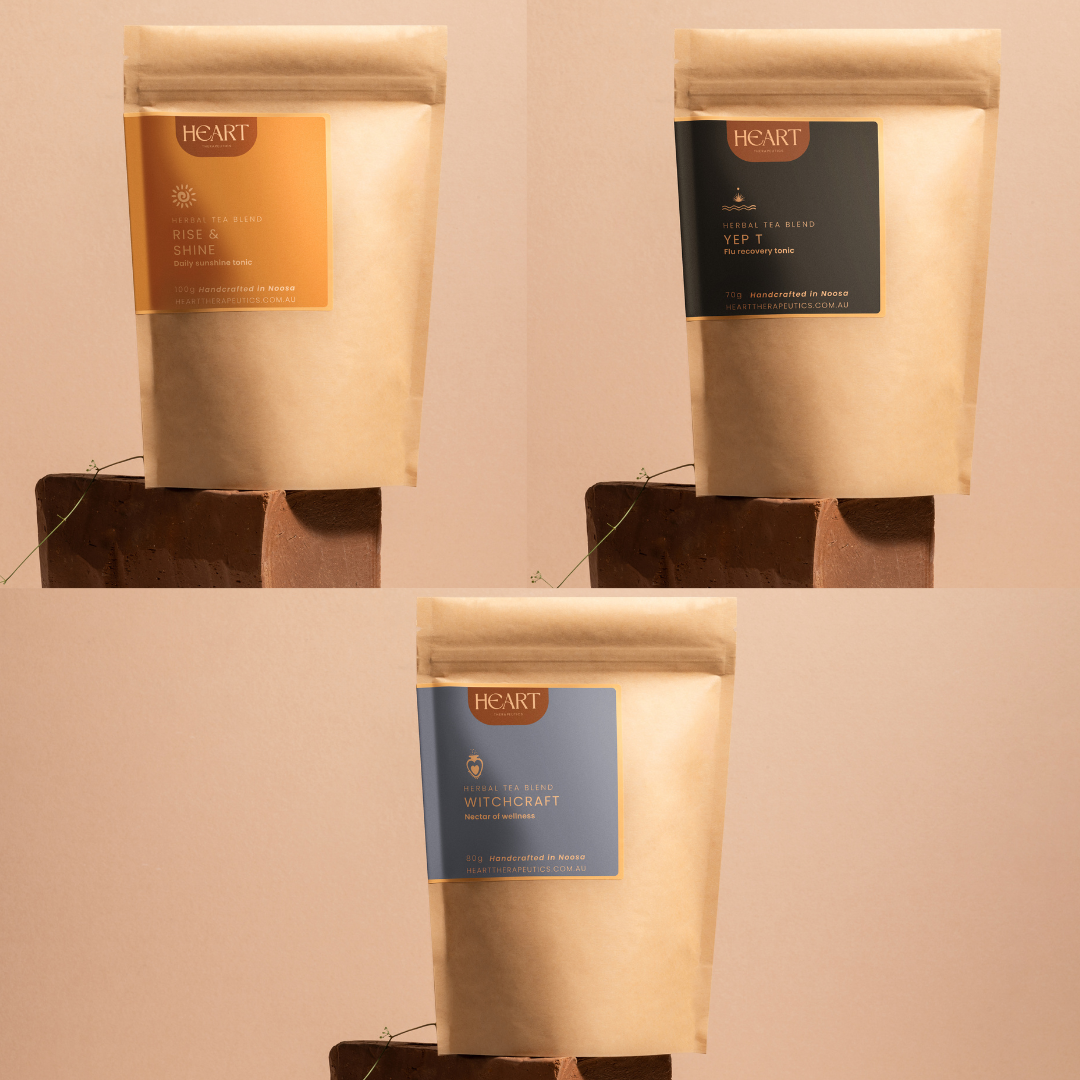 Three packages of Heart Tea Company tea on a beige background